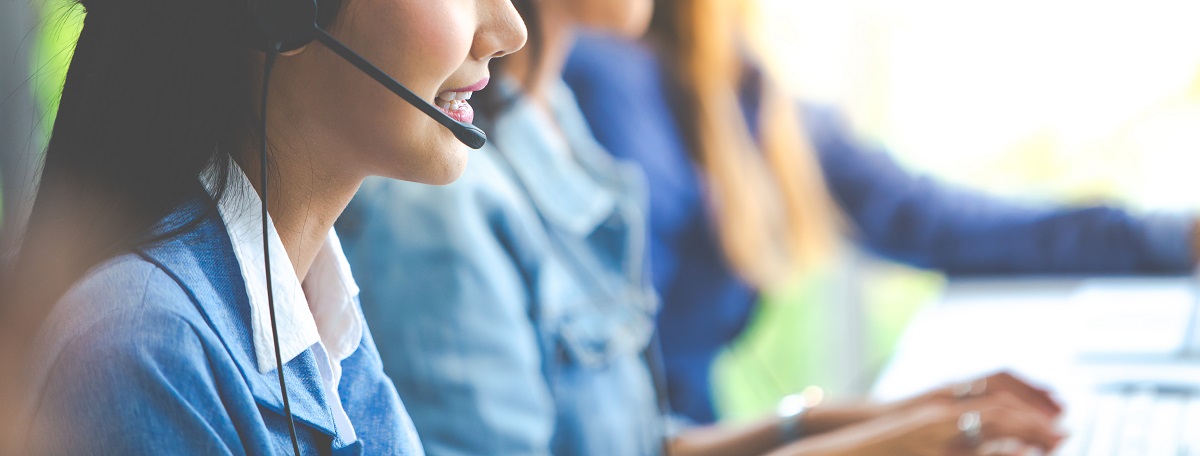 Attractive business woman Asian in suits and headsets are smiling while working with computer at office. Customer service assistant working in office